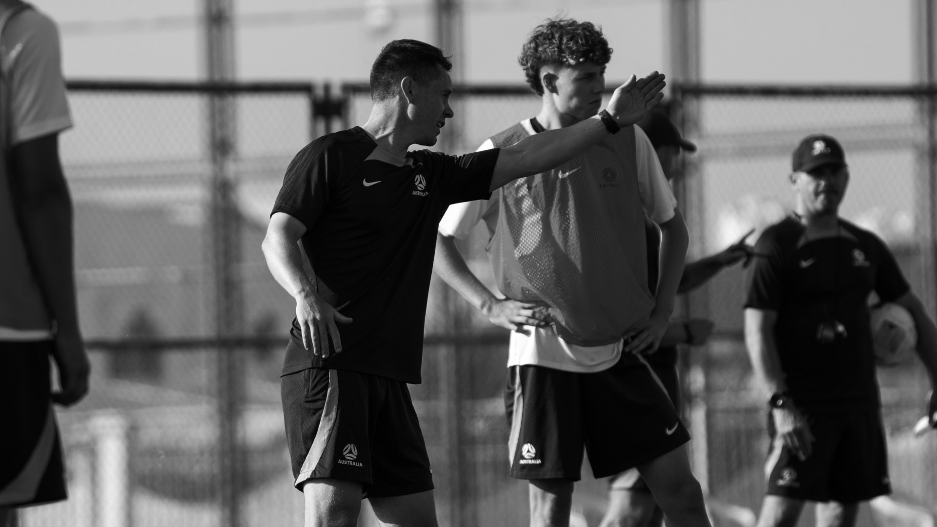 Coach evaluating young football players at practice